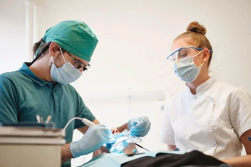 Tandarts en assistente behandelen samen een patiënt